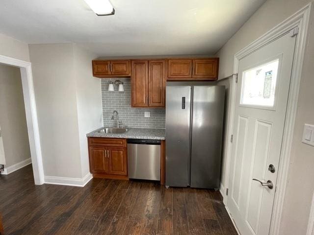 kitchen with stainless steel appliances, a sink, light countertops, and brown cabinets