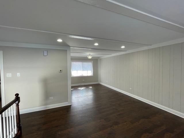 empty room featuring beamed ceiling, recessed lighting, dark wood finished floors, and baseboards