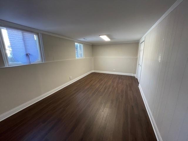 basement featuring baseboards and dark wood finished floors