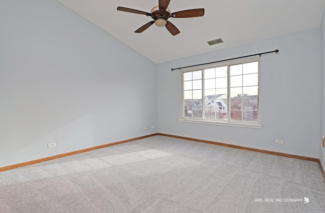 carpeted spare room featuring ceiling fan and vaulted ceiling