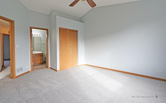 unfurnished bedroom with ceiling fan, ensuite bathroom, lofted ceiling, light carpet, and a closet