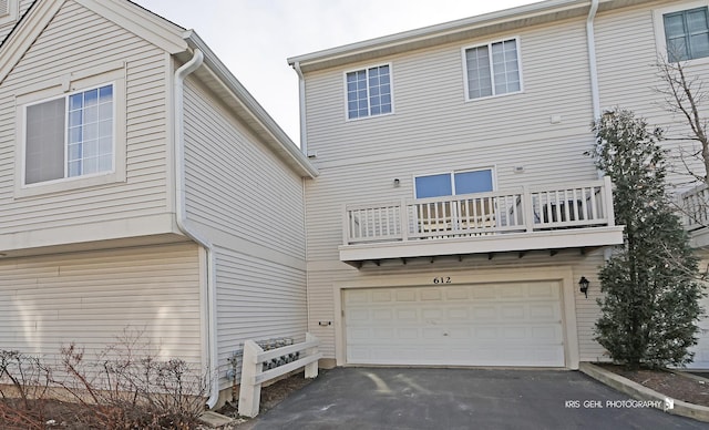 back of property with a balcony and a garage