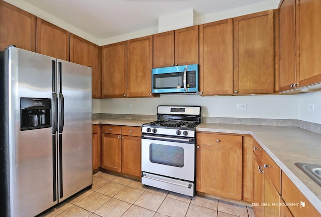 kitchen with light tile patterned floors and appliances with stainless steel finishes