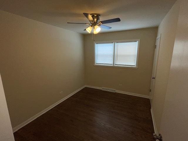 empty room featuring a ceiling fan, baseboards, and dark wood-type flooring