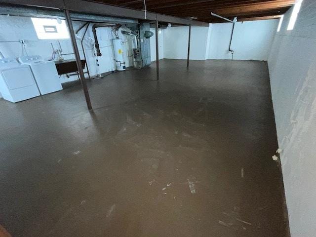 unfinished basement featuring heating unit, water heater, and washing machine and clothes dryer