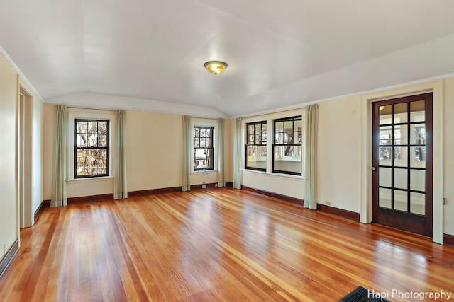 unfurnished room featuring light hardwood / wood-style floors and lofted ceiling