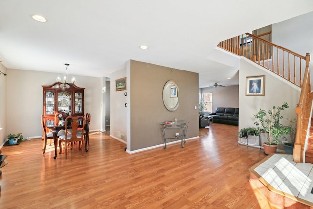 interior space with ceiling fan with notable chandelier and light hardwood / wood-style floors