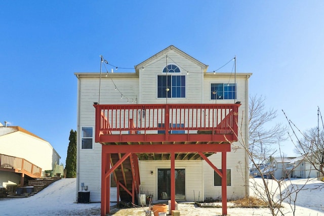 snow covered rear of property featuring a wooden deck