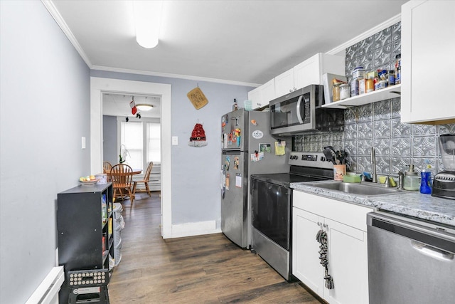 kitchen with appliances with stainless steel finishes, dark hardwood / wood-style floors, white cabinetry, and ornamental molding