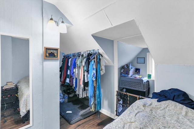 bedroom with dark hardwood / wood-style floors and lofted ceiling