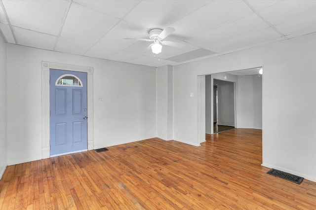 unfurnished room with ceiling fan, a drop ceiling, and wood-type flooring