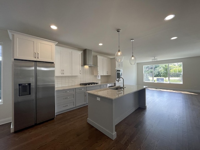 kitchen featuring sink, wall chimney exhaust hood, appliances with stainless steel finishes, dark hardwood / wood-style flooring, and white cabinetry