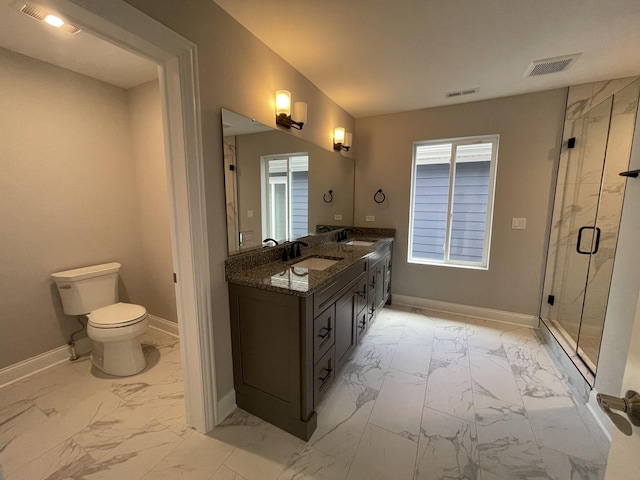 bathroom featuring vanity, a shower with shower door, and toilet