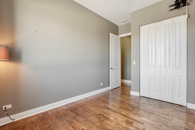 unfurnished bedroom featuring a closet and hardwood / wood-style floors