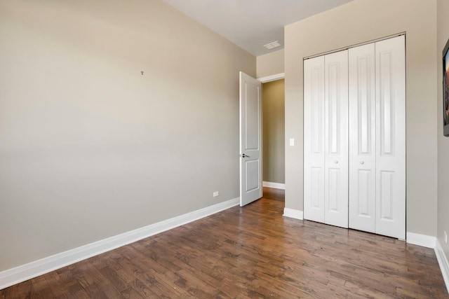 unfurnished bedroom featuring a closet and dark hardwood / wood-style floors