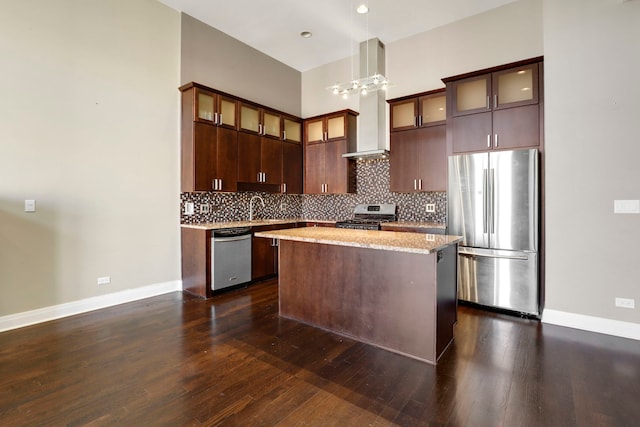 kitchen with a kitchen island, sink, dark brown cabinetry, appliances with stainless steel finishes, and light stone counters