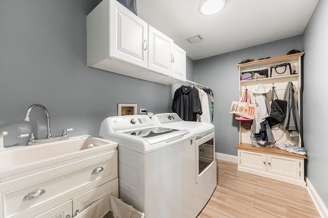 laundry area featuring cabinets, washing machine and dryer, and sink