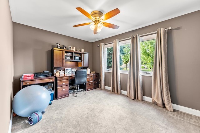 carpeted office space with ceiling fan