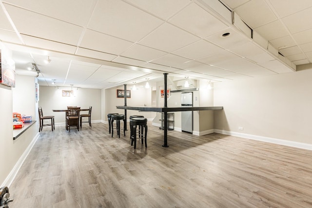 rec room with indoor bar, wood-type flooring, and a paneled ceiling