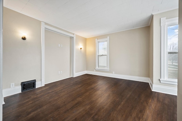 empty room featuring dark hardwood / wood-style flooring and crown molding