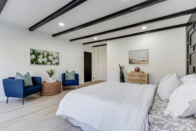 bedroom with beam ceiling and light hardwood / wood-style floors