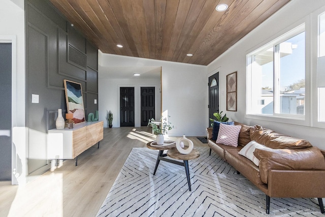 living room featuring lofted ceiling, light hardwood / wood-style floors, and wood ceiling