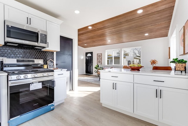 kitchen featuring white cabinetry, wooden ceiling, stove, decorative backsplash, and light wood-type flooring