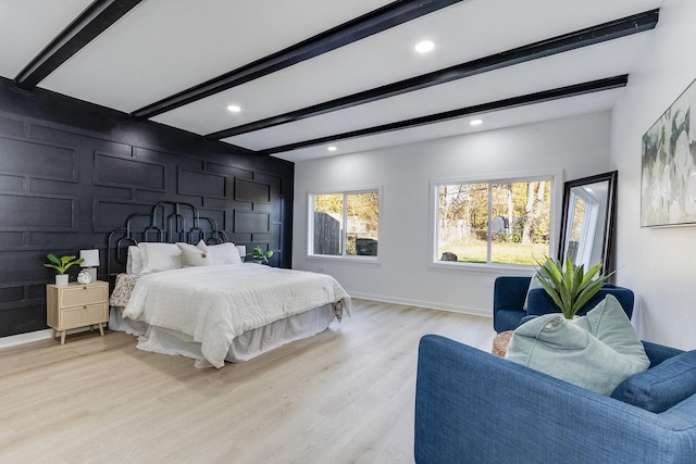 bedroom featuring beam ceiling and light hardwood / wood-style floors