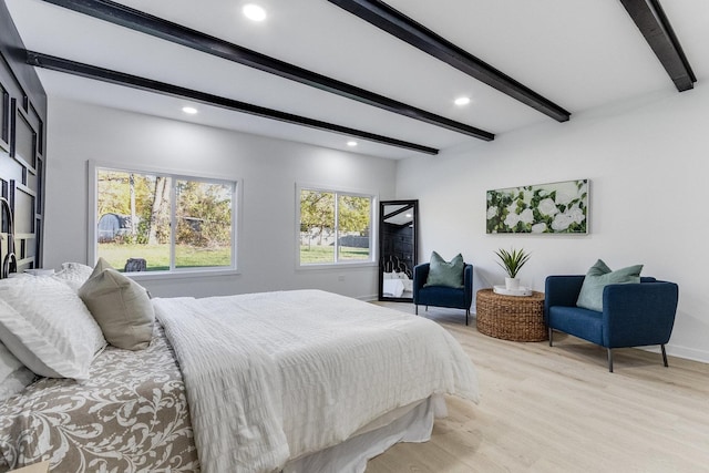 bedroom with beam ceiling and light hardwood / wood-style floors