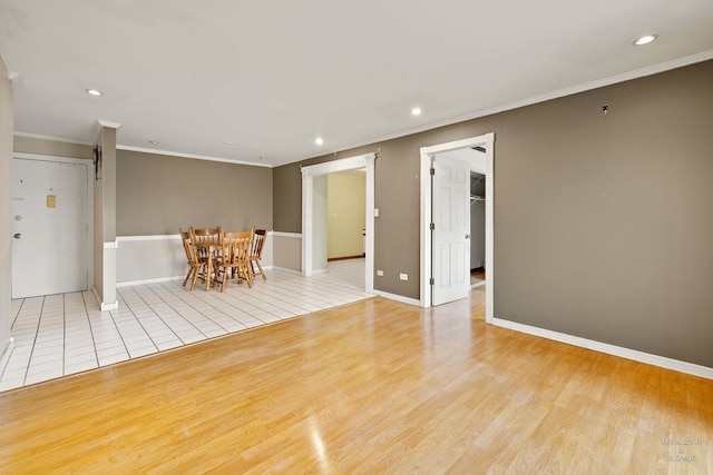 empty room featuring light wood-type flooring and ornamental molding