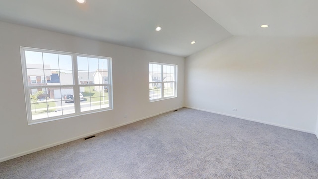 unfurnished room featuring lofted ceiling and light carpet