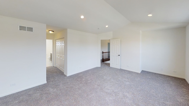 carpeted empty room featuring lofted ceiling