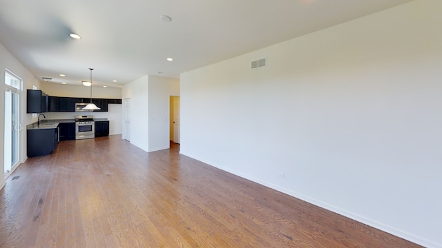 unfurnished living room featuring dark hardwood / wood-style floors and sink