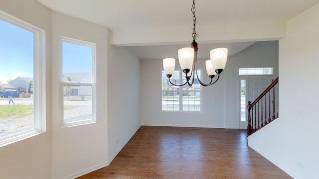 unfurnished dining area with dark hardwood / wood-style floors and an inviting chandelier