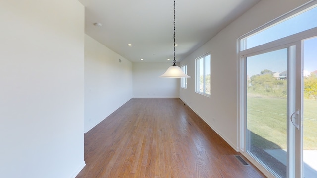 unfurnished dining area featuring hardwood / wood-style floors