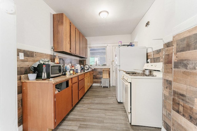 kitchen featuring white range with electric cooktop, decorative backsplash, and light hardwood / wood-style floors