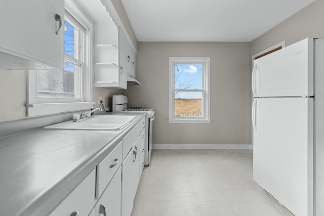 kitchen featuring white cabinets, white appliances, and sink