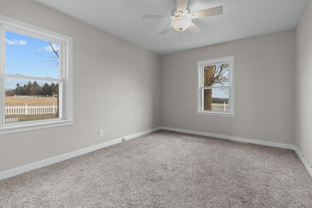 carpeted spare room featuring ceiling fan and a healthy amount of sunlight