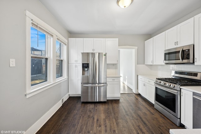 kitchen featuring white cabinets, decorative backsplash, dark hardwood / wood-style floors, and stainless steel appliances