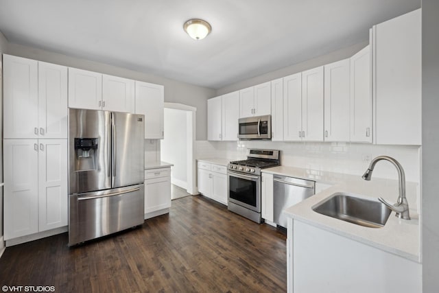 kitchen with sink, stainless steel appliances, dark hardwood / wood-style flooring, backsplash, and white cabinets