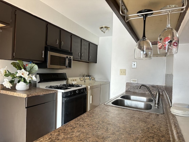 kitchen with dark brown cabinets, white gas range oven, washing machine and dryer, and sink