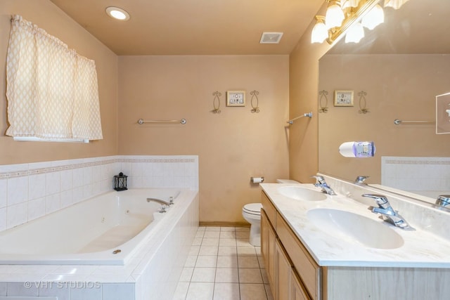 bathroom with tile patterned floors, tiled bath, vanity, and toilet