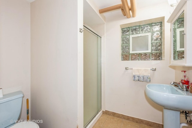 bathroom featuring tile patterned floors, toilet, an enclosed shower, and sink