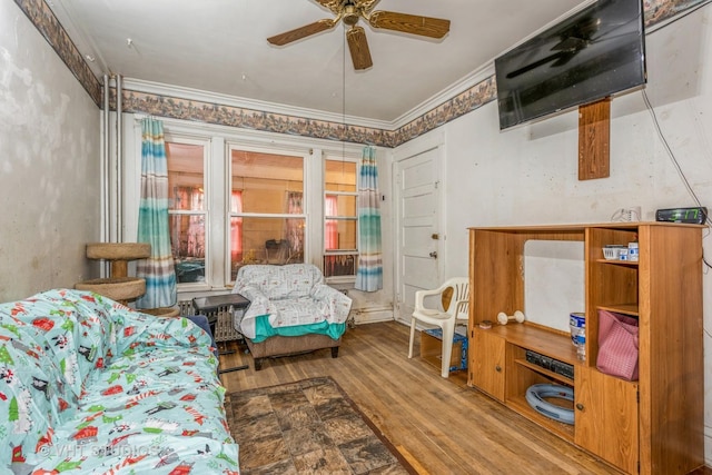 bedroom with hardwood / wood-style flooring, ceiling fan, and ornamental molding