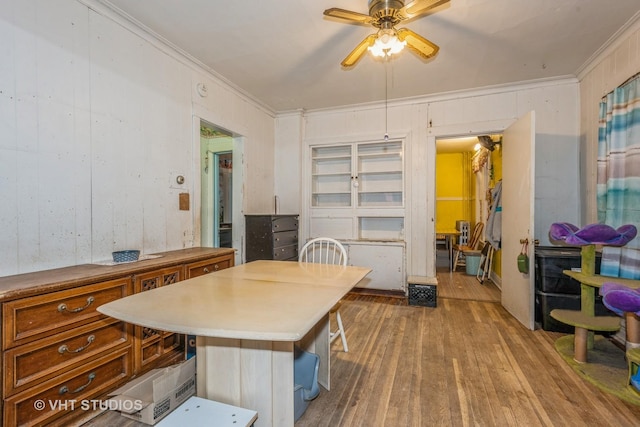 dining space featuring hardwood / wood-style flooring, ceiling fan, and crown molding