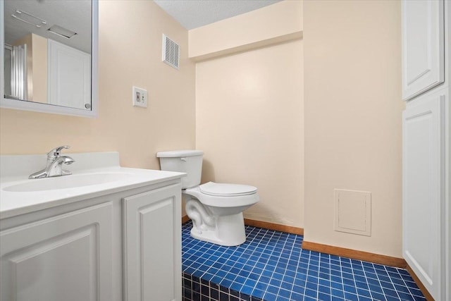 bathroom with vanity, a textured ceiling, and toilet