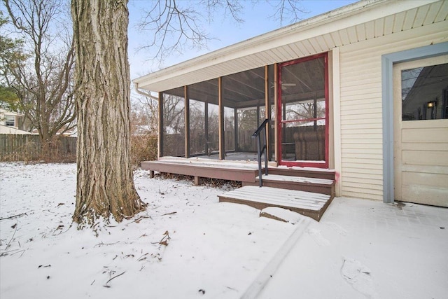 snow covered deck with a sunroom