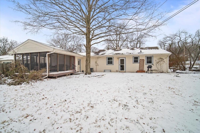 snow covered property featuring a sunroom