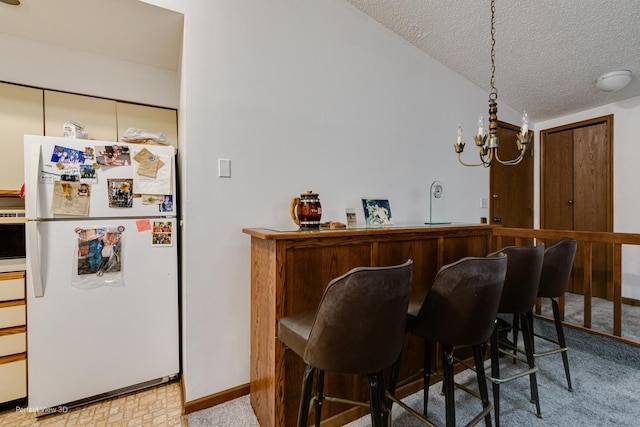 interior space featuring a textured ceiling, bar, and an inviting chandelier