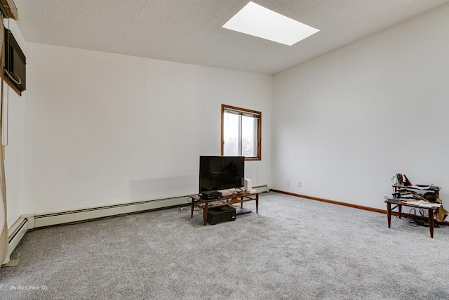 living area featuring a textured ceiling, carpet floors, a skylight, and a baseboard heating unit